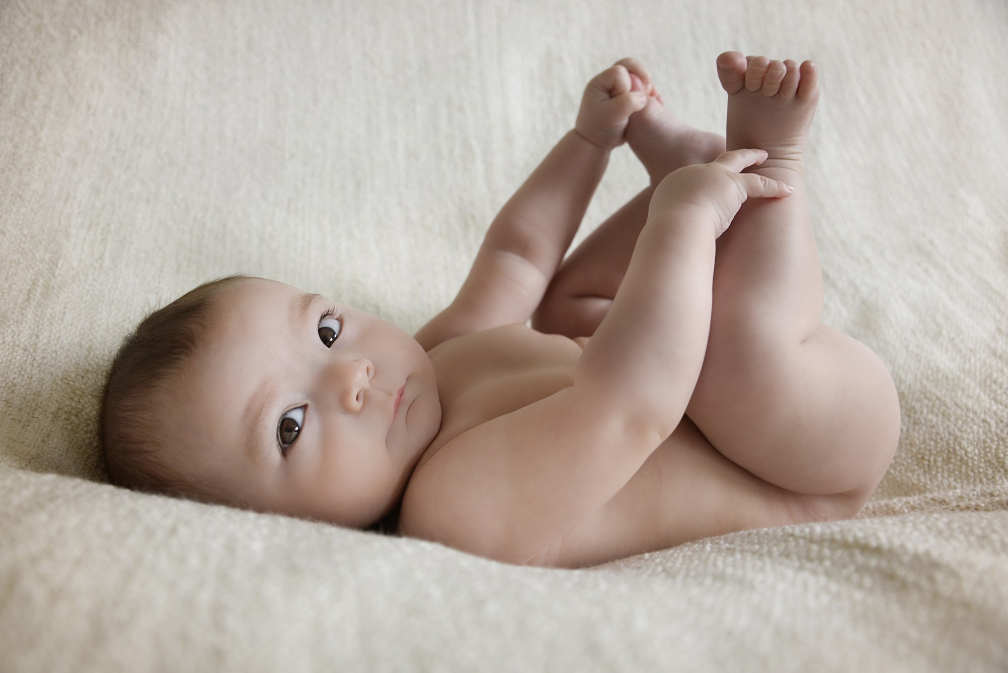 Baby Photography Liverpool - Baby laying on back holding both feet